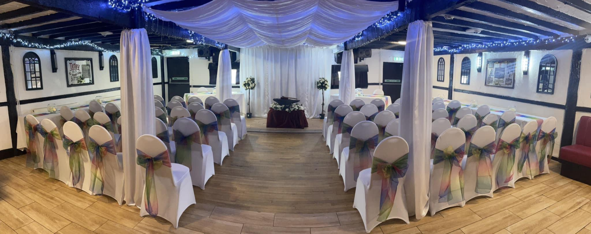 Wedding ceremony setup with decorated chairs.