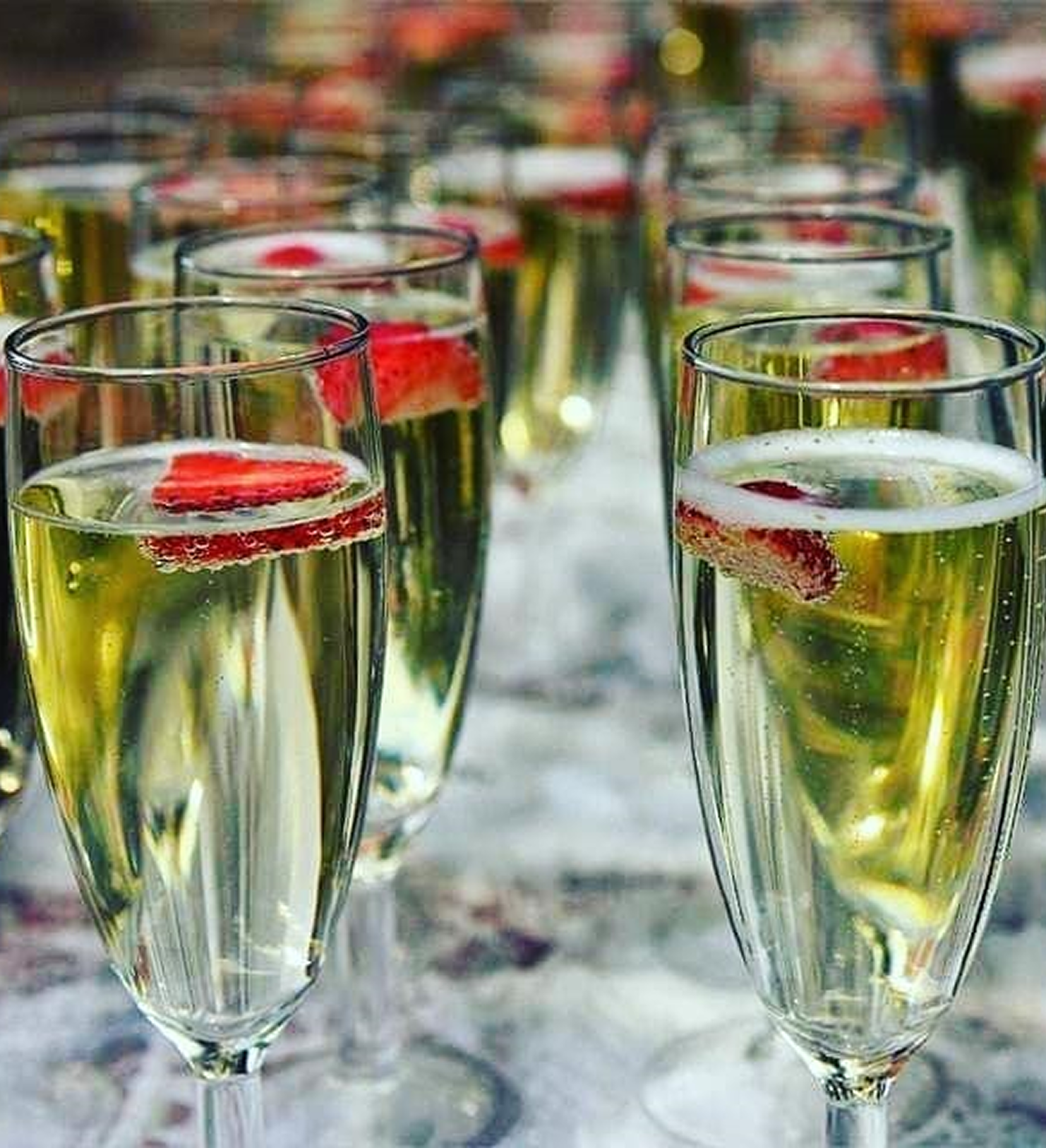 Champagne glasses with strawberry slices.