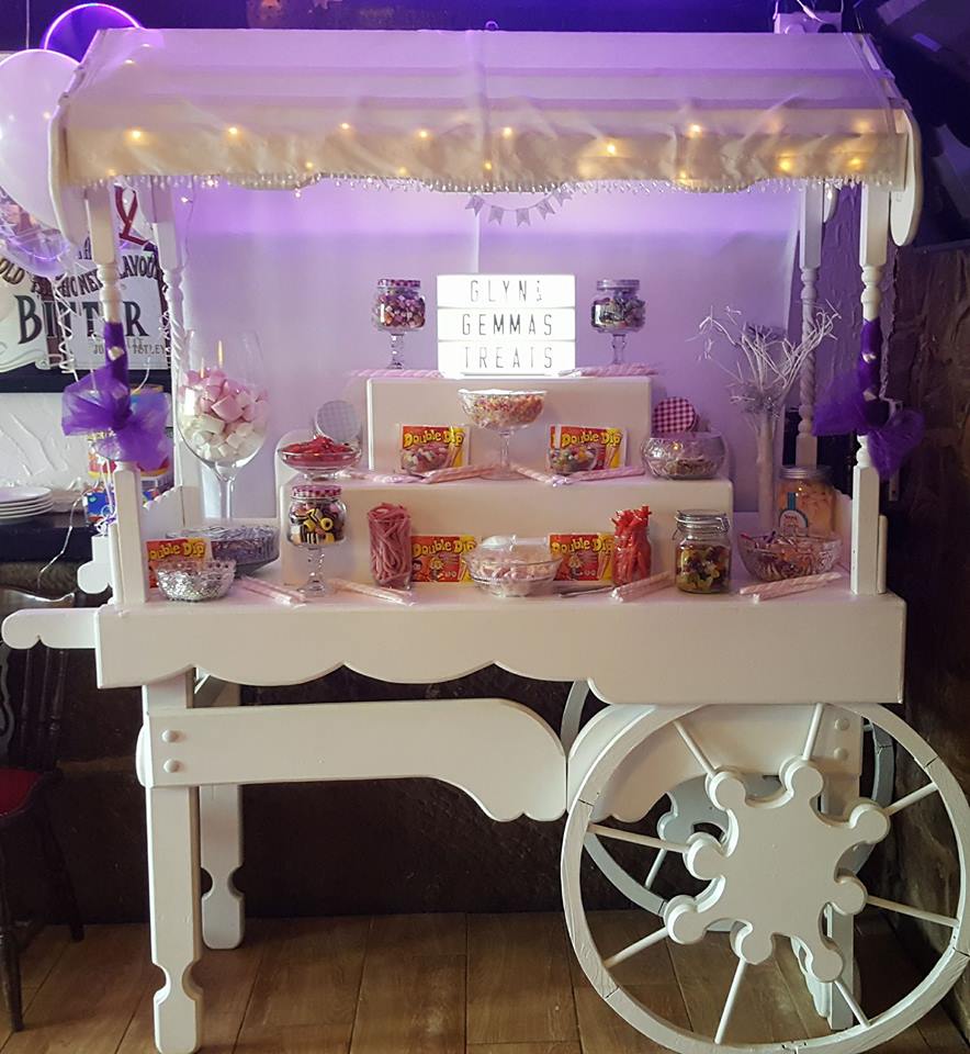White candy cart with assorted sweets displayed.
