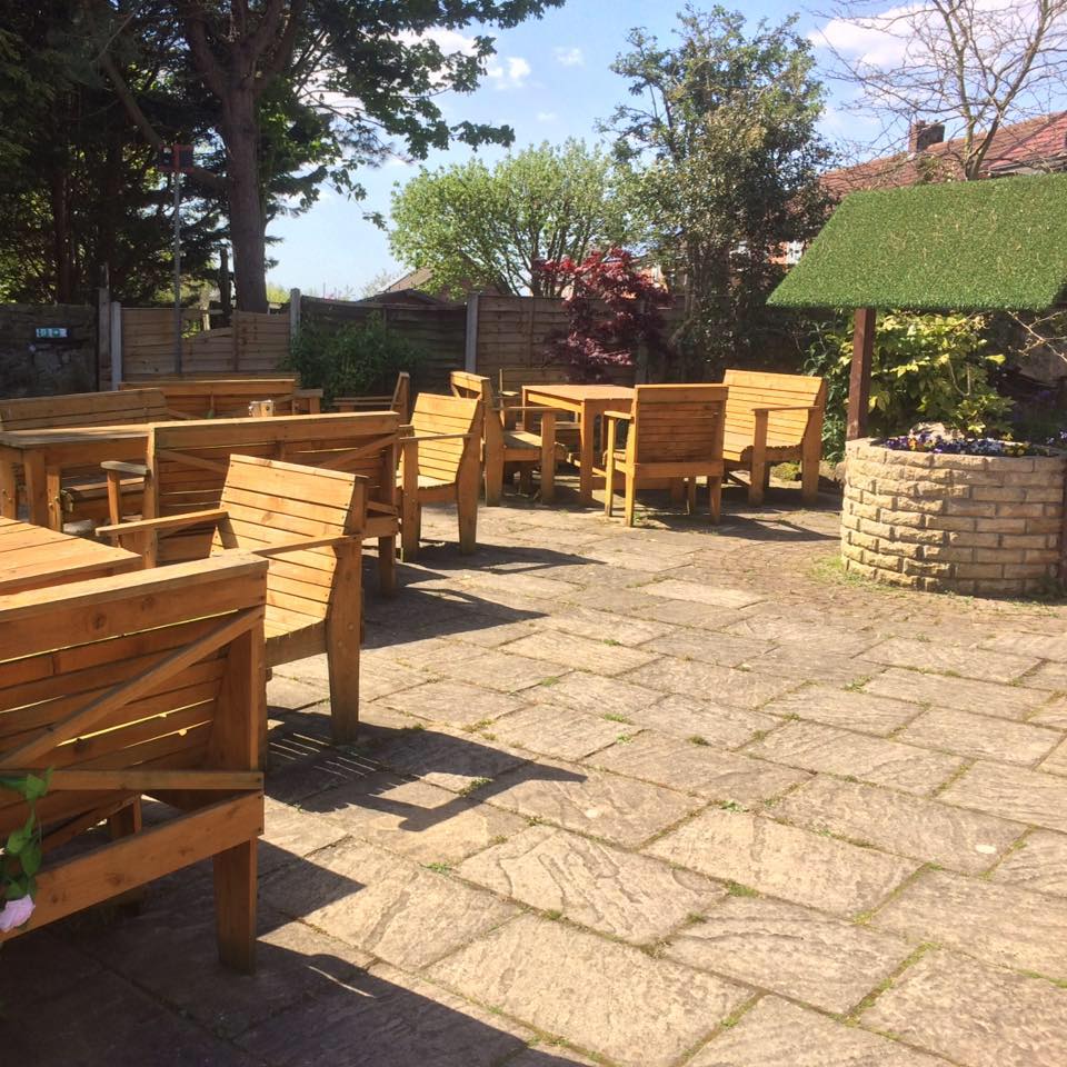 Outdoor patio with wooden seating arrangement.