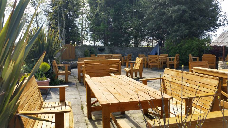 Outdoor patio with wooden tables and benches.