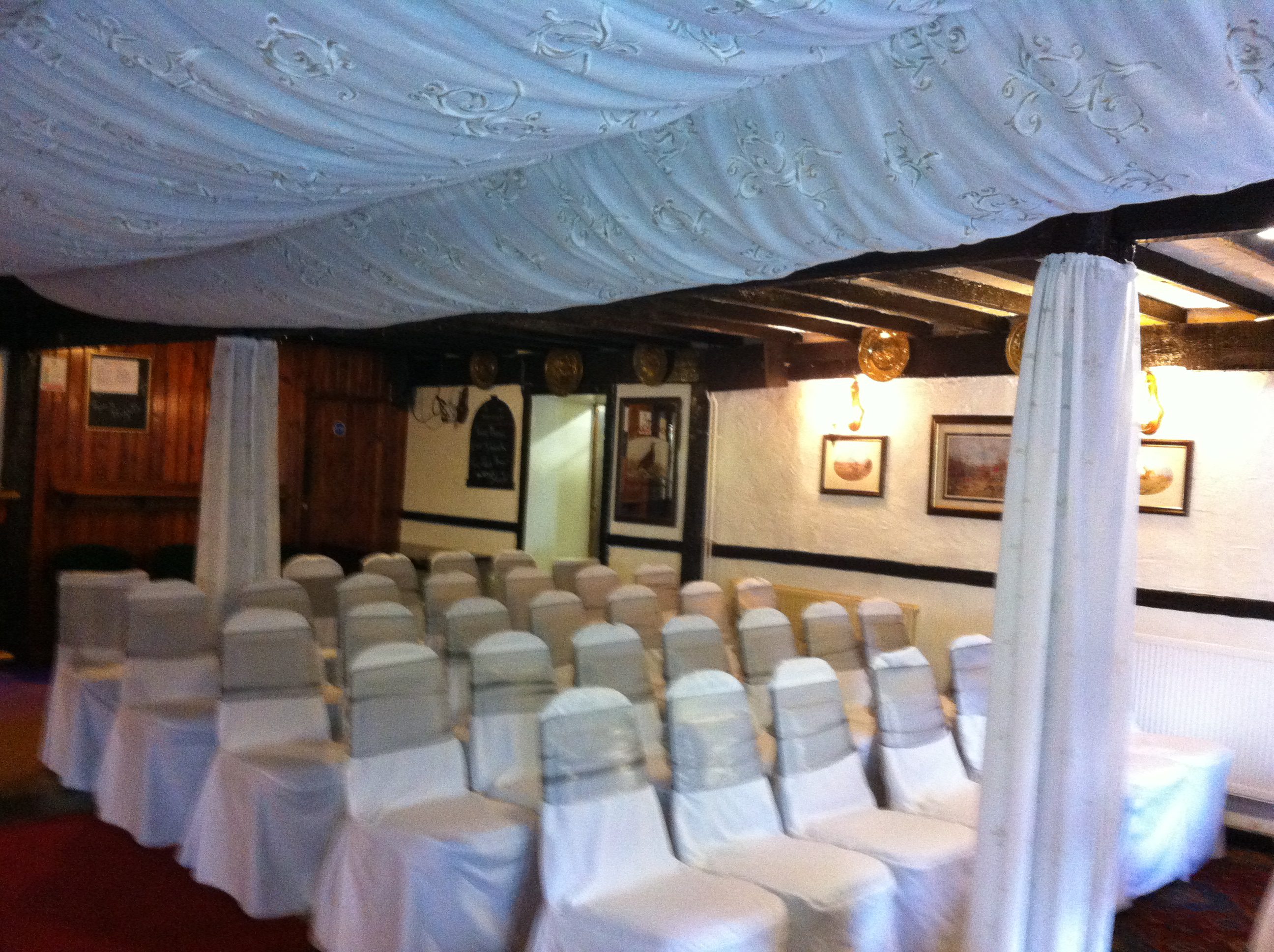 White-covered chairs in decorated event space.