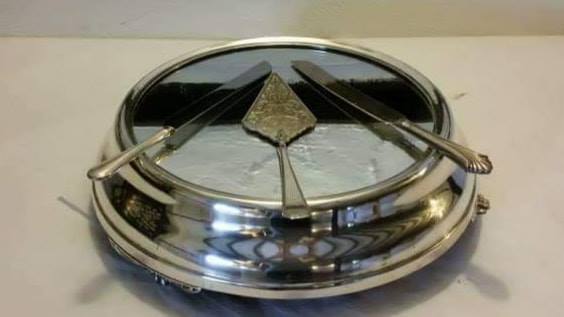 Round tray with three knives arranged symmetrically.
