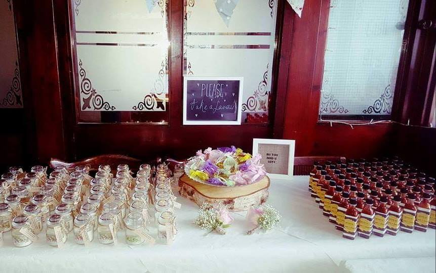 Wedding favors displayed on decorated table.