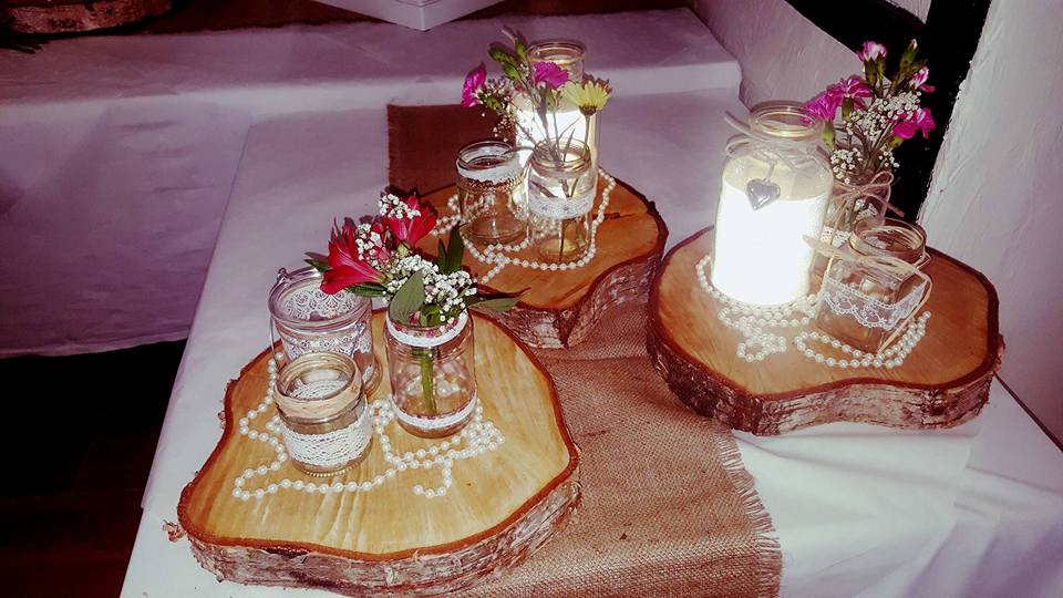 Wooden table centerpiece with jars and flowers.