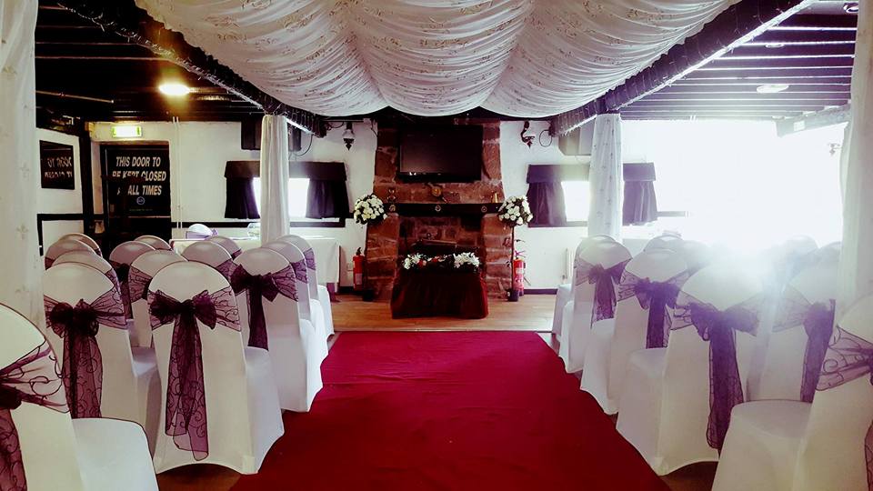 Indoor wedding ceremony setup with red carpet.
